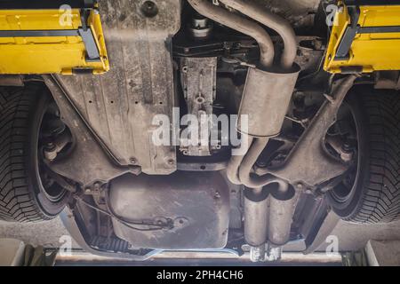 La voiture est sur un ascenseur dans un atelier. Vue de dessous Banque D'Images