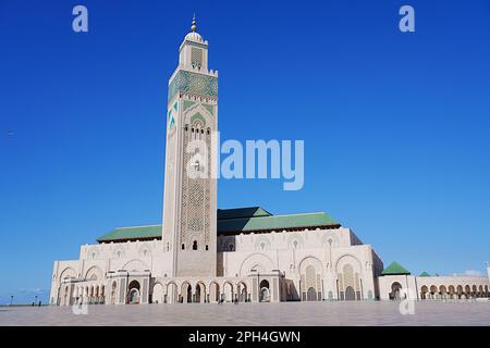 Vue sur la mosquée Hassan II avec minaret à la ville africaine de Casablanca au Maroc, ciel bleu clair en 2023 chaud et ensoleillé jour d'hiver le janvier. Banque D'Images