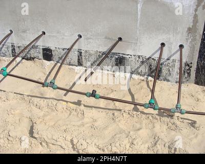 Tuyaux de chauffage au sol en plastique, fondations d'entrepôt en béton. Coussin de sable Banque D'Images