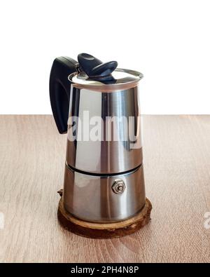 Une cafetière en acier geyser, avec une surface lisse et polie, se tient sur la table. Des briques sur les plats Banque D'Images