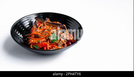 Salade de légumes à l'aubergine frite sur fond clair. Plats végétariens. Laitue isolée dans un bol sombre. Gros plan. Copier l'espace. Banque D'Images