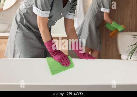 Chambres professionnelles nettoyant la salle de bains dans l'hôtel, à proximité Banque D'Images