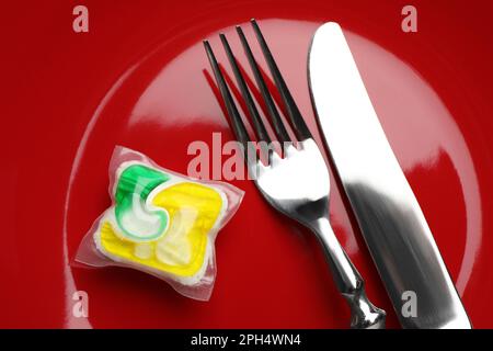 Assiette rouge avec couverts et porte-détergent pour lave-vaisselle, vue de dessus Banque D'Images