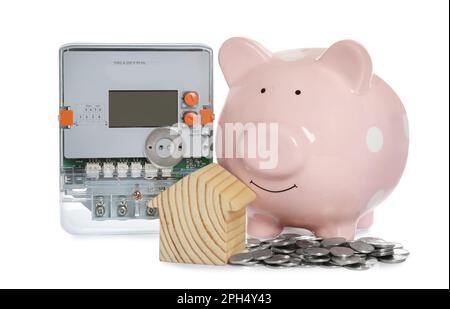 Compteur d'électricité, modèle de maison, banque de porc et pièces de monnaie sur fond blanc Banque D'Images