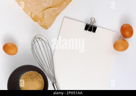 Bloc-notes de recette vierge pour la cuisson et la cuisson sur fond de table lumineuse avec outils et fournitures de cuisine Banque D'Images