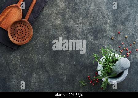 Romarin frais et safran dans du mortier de marbre et des cuillères en bois sur fond de pierre noire. Cuisine de fond. Ingrédients pour la cuisson des aliments Backgr Banque D'Images