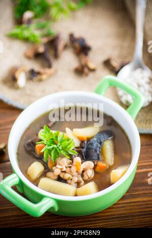 soupe chaude aux champignons avec haricots dans un bol, sur une nappe rustique en toile de jute. Banque D'Images