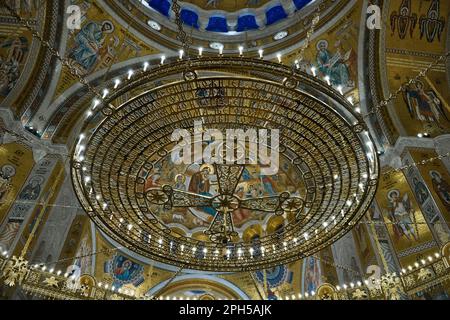 Lustre et fresques lumineuses sur des thèmes bibliques au plafond. Vue à angle bas du dôme de l'église Saint-Sava, Belgrade, Serbie - février 2023 Banque D'Images