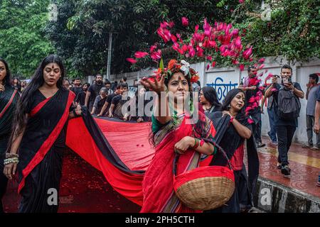 Un artiste a vu lancer des fleurs lors d'une représentation de Lal Jatra (procession rouge) alors qu'il se déroule sur le campus de l'Université de Dhaka. L'école d'action et de conception de Prachyanat a organisé une procession de Lal Jatra (procession rouge), pour se rappeler le génocide commis par l'armée pakistanaise à 25 mars 1971 à Dhaka, au Bangladesh, sur 25 mars 2023. En cette nuit noire de l'histoire nationale, les dirigeants militaires pakistanais ont lancé « l'opération Searchlight », tuant quelques milliers de personnes dans la seule répression de cette nuit-là. Dans le cadre de l'opération, des chars ont été déployés hors du cantonnement de Dhaka et une ville endormie s'est réveillée aux coups de fusil Banque D'Images
