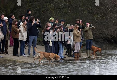 Spectateurs sur la rive en regardant la course des femmes pendant la course de bateaux Gemini 77th 2023 sur la Tamise, Londres. Date de la photo: Dimanche 26 mars 2023. Banque D'Images