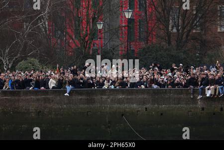 Spectateurs sur la rive en regardant la course des femmes pendant la course de bateaux Gemini 77th 2023 sur la Tamise, Londres. Date de la photo: Dimanche 26 mars 2023. Banque D'Images