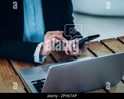 Mode silencieux. Icône de son silencieux Activer activé apparaît dans la bulle de la voix sur le smartphone mobile à portée de main pendant que le professionnel travaille avec Banque D'Images