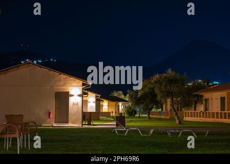 Moraitika, Grèce - 09 23 2022: Nuit photo de la zone d'hôtel avec des bungalows, en arrière-plan Silhouette des montagnes et Starry Sky. Banque D'Images