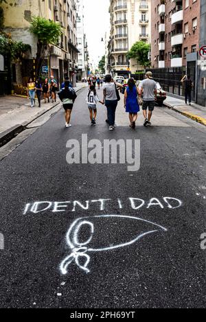 24 mars 2023: Familias vuelven a sus casas por una calle de Buenos Aires, intervenida con un grafitti con la palabra ''Identidad' y una Pañuelo blanco, sÃ-mbolo de las Madres y Abuelas de Plaza de Mayo; Luego de la marcha por el DÃ-a de la Memoria./les familles retournent dans leur maison par une rue à Buenos Aires, sont intervenus avec un graffiti avec le mot ''identité'' et un mouchoir blanc, symbole des mères et des grands-mères de la Plaza de Mayo; Après la marche pour le jour du souvenir./El DÃ-a Nacional de la Memoria por la Verdad y la Justicia es un dÃ-a feriado inamovible de Argentina qu Banque D'Images