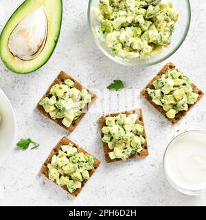 Salade d'oeufs d'avocat sur le pain sur fond de pierre légère. Vue de dessus, plan d'appartement Banque D'Images