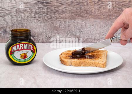 Londres, Royaume-Uni - 21 mars 2023 : marmite se répandant sur une tranche de pain grillé. Marmite est un extrait de levure riche en vitamine B. M. Banque D'Images