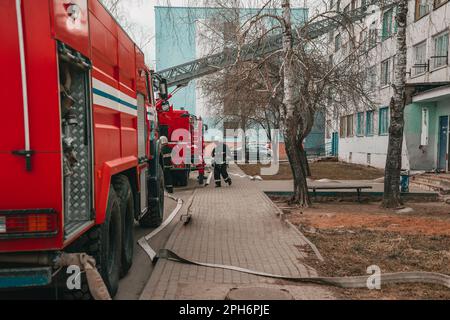 pompiers de deux voitures en formation près d'un bâtiment résidentiel Banque D'Images