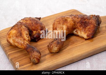 Cuisses de poulet sur une planche à découper en bois Banque D'Images