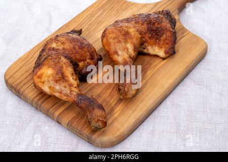 Cuisses de poulet sur une planche à découper en bois Banque D'Images