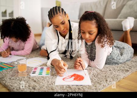 Maman et filles noires peinture se trouvant à la maison Banque D'Images