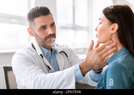 Médecine, santé et contrôle médical concept. Un médecin de sexe masculin vérifie les amygdales du patient à l'hôpital Banque D'Images