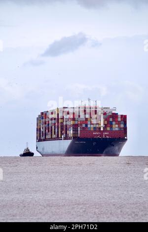 Le bateau à conteneurs Maersk Compton entre dans le port de Felixstowe, Suffolk, Royaume-Uni, assisté de remorqueurs. Banque D'Images