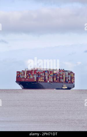 Le bateau à conteneurs Maersk Compton entre dans le port de Felixstowe, Suffolk, Royaume-Uni, assisté de remorqueurs. Banque D'Images