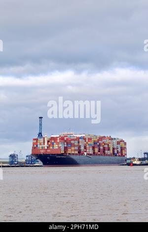 Le bateau à conteneurs Maersk Compton entre dans le port de Felixstowe, Suffolk, Royaume-Uni, assisté de remorqueurs. Banque D'Images