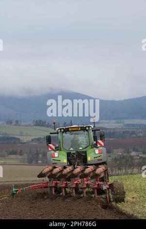 Vue arrière d'un tracteur Fendt équipé d'une charrue réversible Kverneland opérant dans le Rural Aberdeenshire le matin d'une journée de fonte Banque D'Images