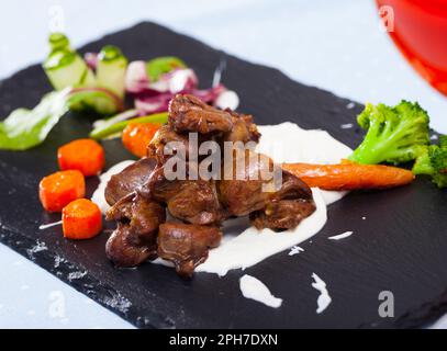 Cœurs de poulet grillés avec sauce et légumes Banque D'Images