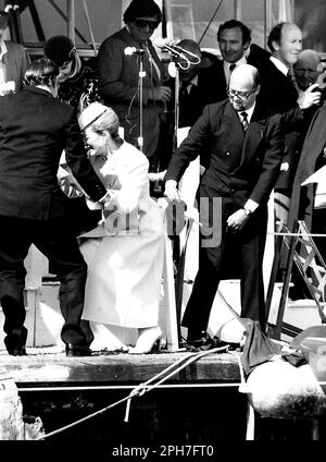 AJAXNETPHOTO. 26TH MARS 1982. COWES, ANGLETERRE. - LANCEMENT DU YACHT DE LA COUPE DE L'AMÉRIQUE - H.R.H. LA PRINCESSE MICHAEL DE KENT A ÉTÉ AIDÉE GRACIEUSEMENT À TERRE ET DANS SES CHAUSSURES APRÈS UNE VISITE PIEDS NUS DU YACHT QU'ELLE VENAIT DE NOMMER TANDIS QUE LE PROPRIÉTAIRE DE LA VICTOIRE MARCHAND BANQUIER PETER DE SAVARY (À DROITE) FUMBLES AVEC SON BROGUES. LA PRINCESSE SEMBLE TROUVER LA SITUATION DÉLICATE DE MR DE SAVARY AMUSANTE. PHOTO:JONATHAN EASTLAND/AJAX REF:222904 MX340 19 (VOIR AUSSI 222904 MX340 17 ET 18) Banque D'Images