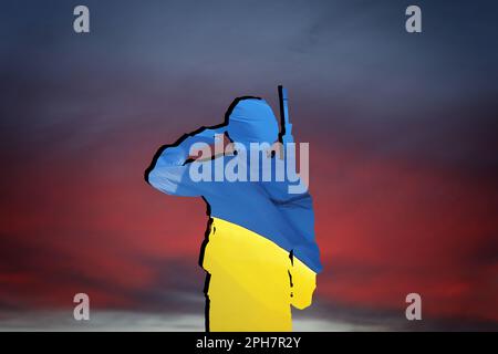 Silhouette de soldat en couleur du drapeau ukrainien avec fusil d'assaut contre le ciel au coucher du soleil Banque D'Images