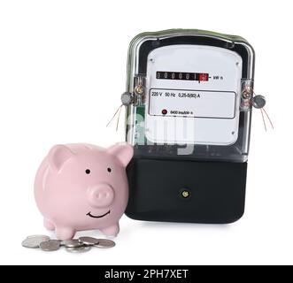 Compteur d'électricité, banc de porc rose et pièces de monnaie sur fond blanc Banque D'Images