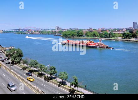 Bateau à vapeur et barge rouge sur la rivière est. Vue en angle supérieur est du trafic commercial sur la FDR Drive à New York, États-Unis Banque D'Images