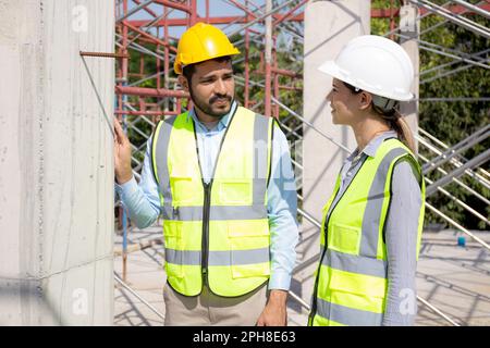 Jeune architecte homme et femme parlant pour la planification de l'aménagement immobilier et de la maison au chantier de construction, entrepreneur ou réunion d'ingénieur et di Banque D'Images