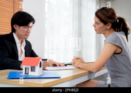 Jeune femme cliente discutant avec l'agent de l'achat de contrat maison et de l'accord de succession hypothécaire et expliquant pour la planification dans le bureau à domicile, f Banque D'Images