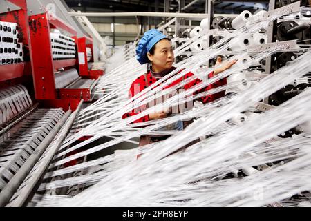 LIANYUNGANG, CHINE - le 27 MARS 2023 - Un travailleur fabrique des produits textiles sur une chaîne de production dans une entreprise privée de Lianyungang Economic and Technol Banque D'Images