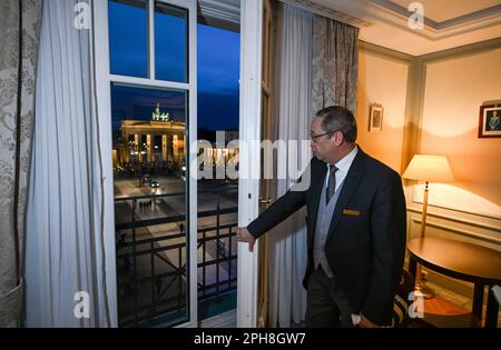 Berlin, Allemagne. 16th mars 2023. Le Butler Ricardo Dürner se trouve dans la suite royale de l'hôtel Adlon et offre une vue sur la porte de Brandebourg. Certains détails d'une visite royale sont traditionnellement calmes. Selon les initiés, le roi Charles III restera probablement là où sa mère la reine Elizabeth II était déjà un invité. L'une des trois suites présidentielles de l'hôtel Adlon a été nommée la suite royale en son honneur. Credit: Jens Kalaene/dpa/Alamy Live News Banque D'Images