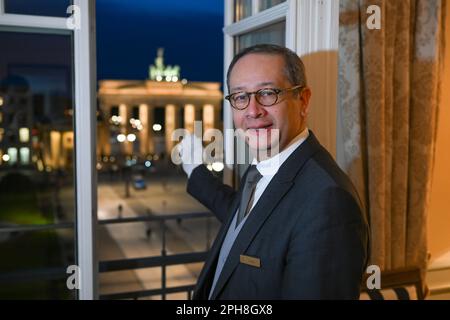 Berlin, Allemagne. 16th mars 2023. Le Butler Ricardo Dürner se trouve dans la suite royale de l'hôtel Adlon et offre une vue sur la porte de Brandebourg. Certains détails d'une visite royale sont traditionnellement calmes. Selon les initiés, le roi Charles III restera probablement là où sa mère la reine Elizabeth II était déjà un invité. L'une des trois suites présidentielles de l'hôtel Adlon a été nommée la suite royale en son honneur. Credit: Jens Kalaene/dpa/Alamy Live News Banque D'Images