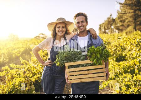 Quand son organique, vous savez son bien. un jeune homme et une jeune femme travaillant ensemble dans une ferme. Banque D'Images