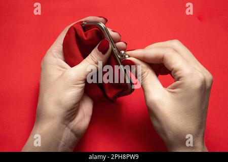 vieux portefeuille rouge et main femelle sur fond isolé de près Banque D'Images