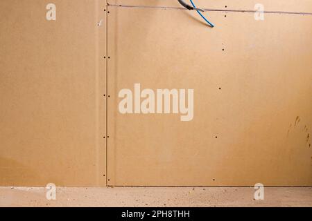 Panneaux de gypse brun installés sur le mur de séparation du bâtiment en construction sur le chantier de construction. Banque D'Images