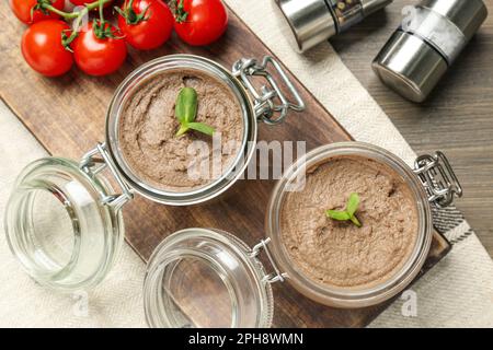 Pots en verre avec délicieux pâté de foie sur une table en bois, plat Banque D'Images