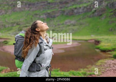 Profil d'un randonneur respirant de l'air frais au bord d'une rivière Banque D'Images