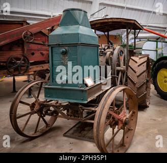 Un vieux tracteur agricole de conception classique, avec un extérieur rustique, assis dans un champ de haute herbe Banque D'Images