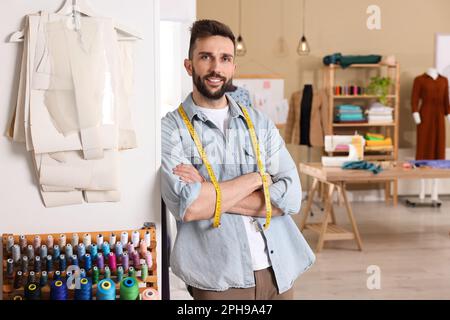 Bonne couturière avec mètre ruban en atelier Banque D'Images