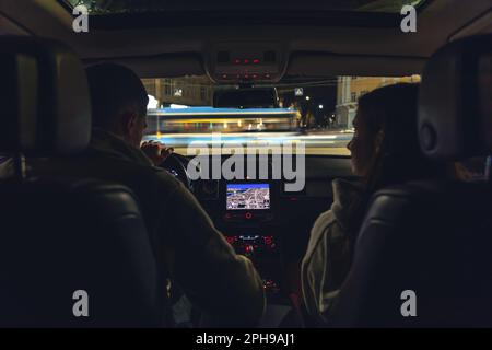 Homme et femme dans une voiture la nuit, vue de la voiture. Banque D'Images