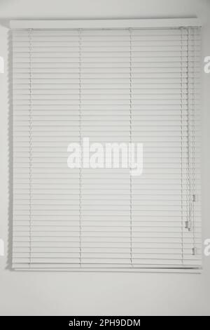 Fenêtre avec stores blancs fermés dans la chambre Banque D'Images