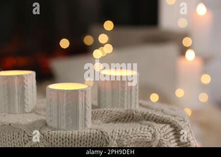 Bougies allumées sur un tissu écossais dans la chambre. Effet bokeh Banque D'Images