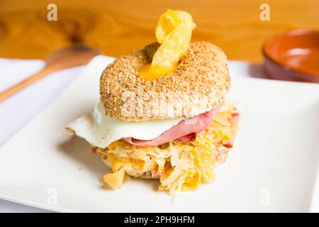 Délicieux sandwich au jambon et aux œufs sur du pain de bagel. Un bagel est un pain traditionnellement fait de farine de blé et a habituellement un trou au centre. Banque D'Images